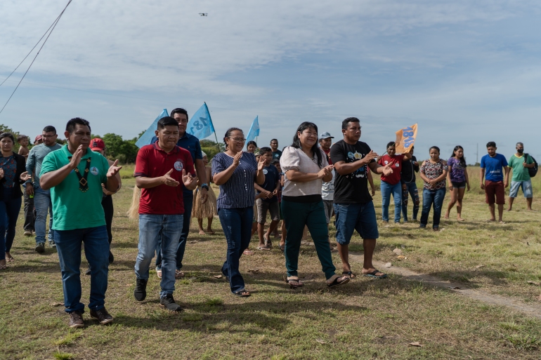 Joenia Wapichana arrives at a political campaign event surrounded by supporters on Raposa Serra do Sol Indigenous land.